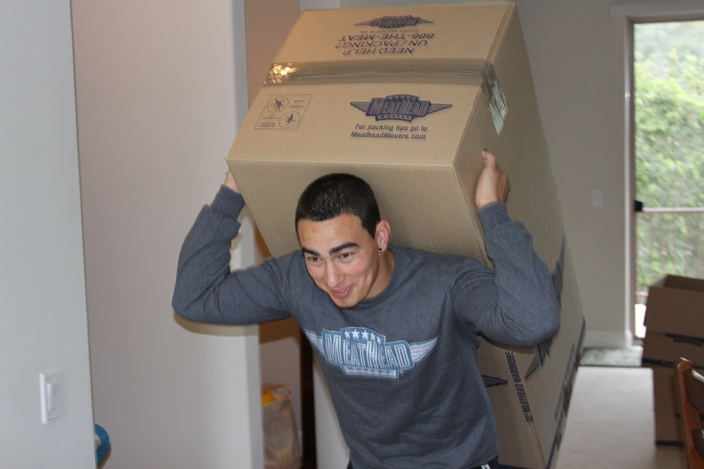 Person carrying a moving box on their back, illustration of a move in progress.
