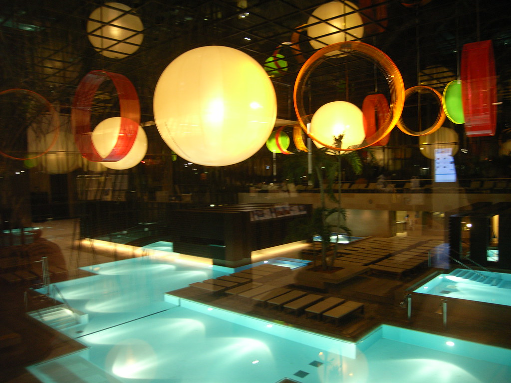 Indoor thermal wellness pool with soft lighting and luxury architecture.