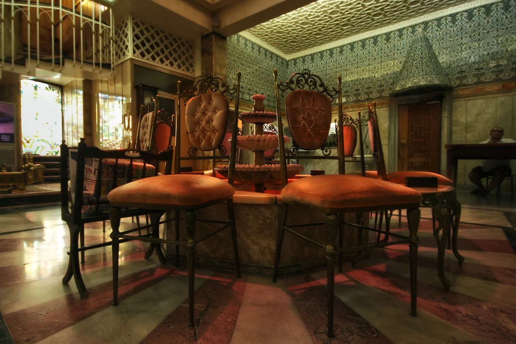 Resting room of a traditional hammam with a fountain, mosaics and a marble floor.