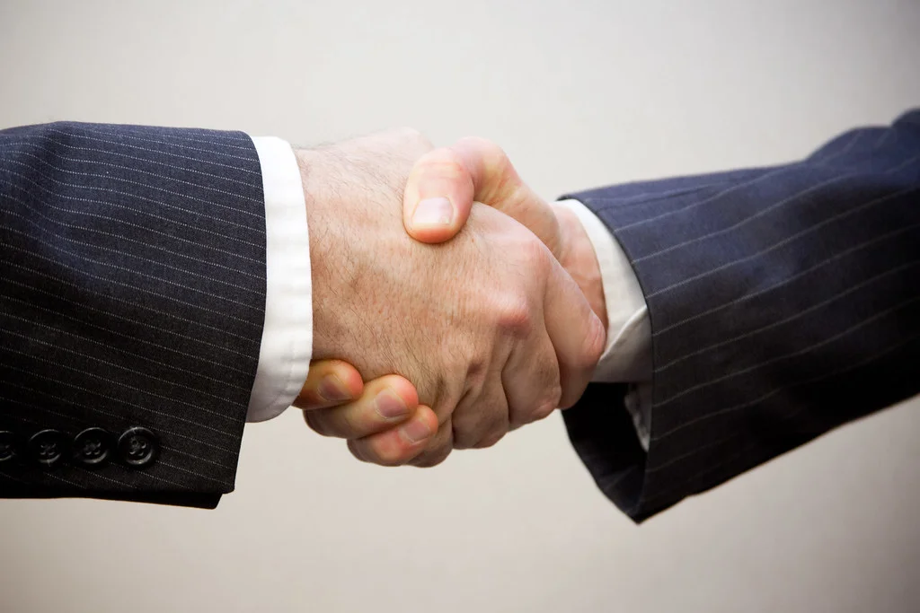 Poignée de main entre un dirigeant et son conseiller en agence.