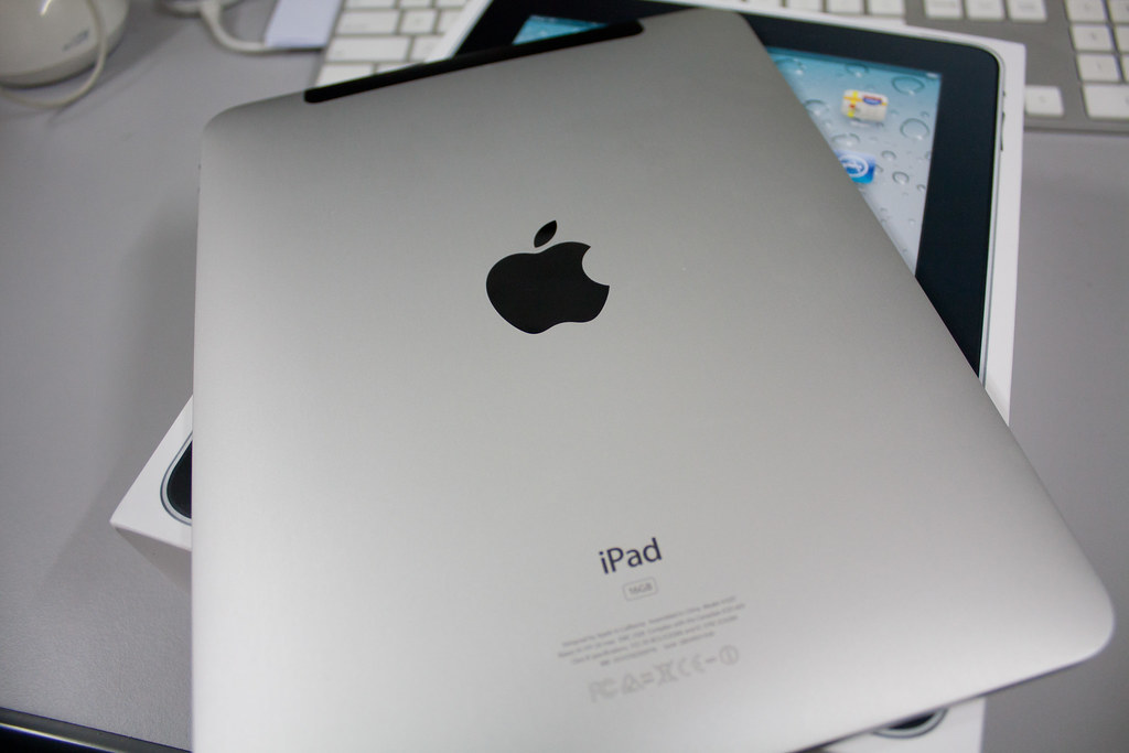 Refurbished iPad on a white surface with screen on, ready to use