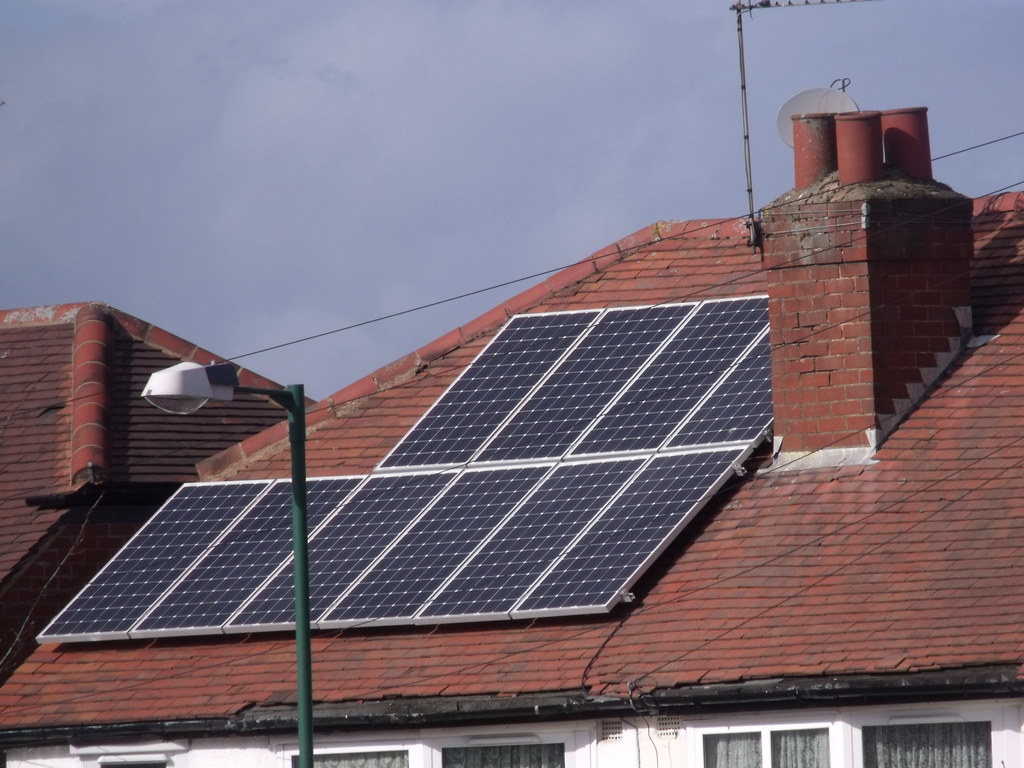 Panneaux solaires photovoltaïques posés sur la toiture en tuiles d'une maison individuelle.