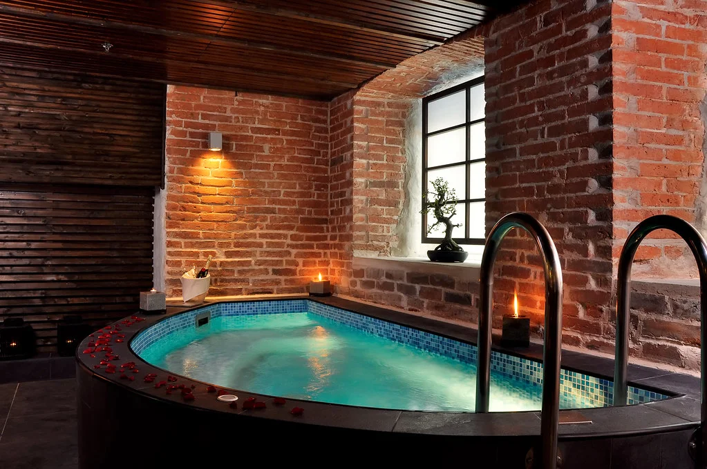 Bassin d'un spa d'hôtel de luxe éclairé, avec transats et ambiance zen japonaise